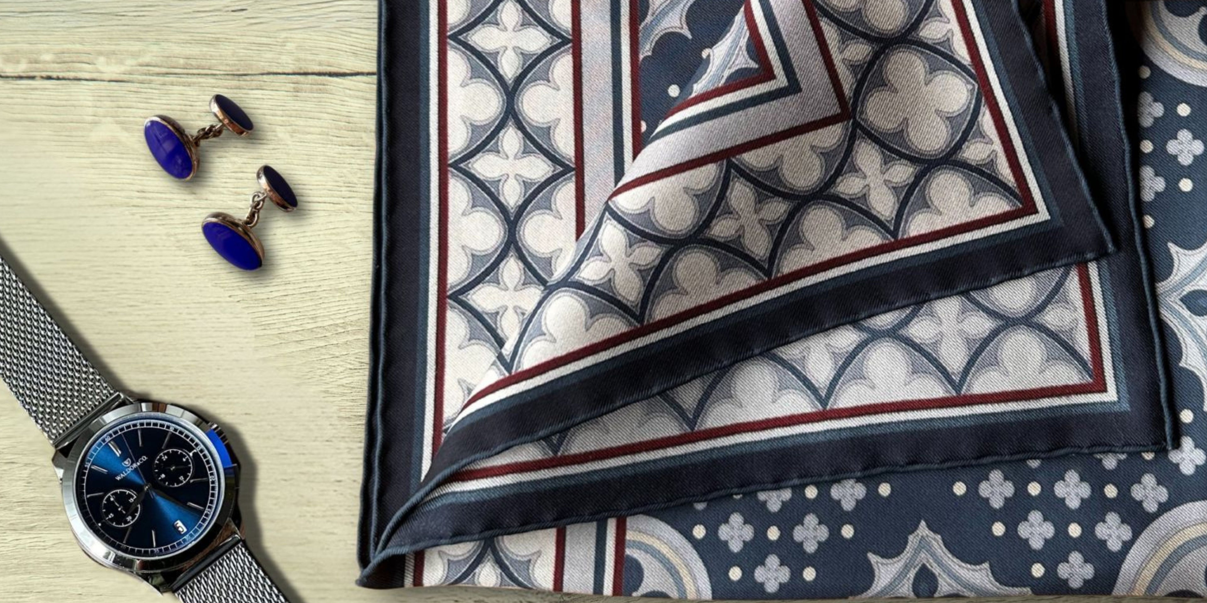 Venetian themed pocket square with cufflinks and watch on a wooden surface