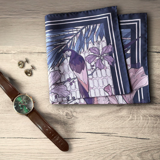 Pink purple, and navy blue pocket square folded on a rustic wooden table next to a brown leather watch and bronze cufflinks 
